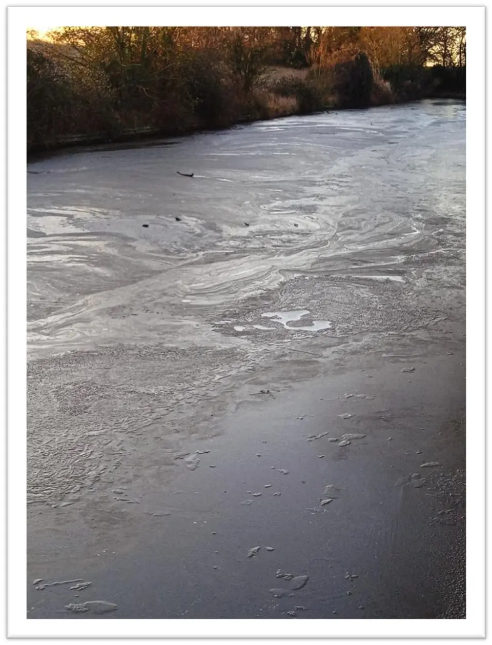 Swirling ice patterns on the frozen surface of the canal. 