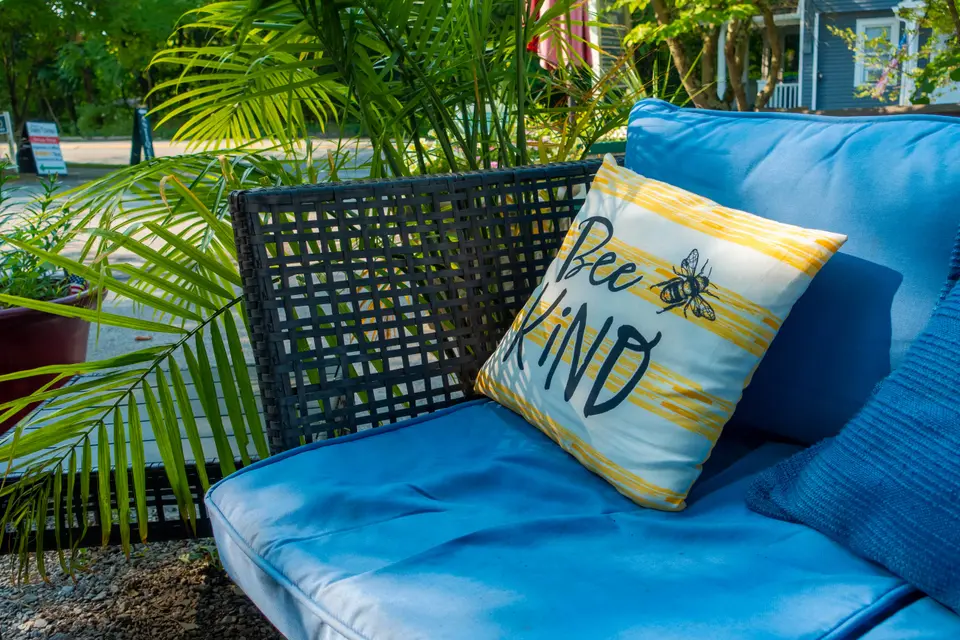 Outdoor seating with a Bee Kind pillow