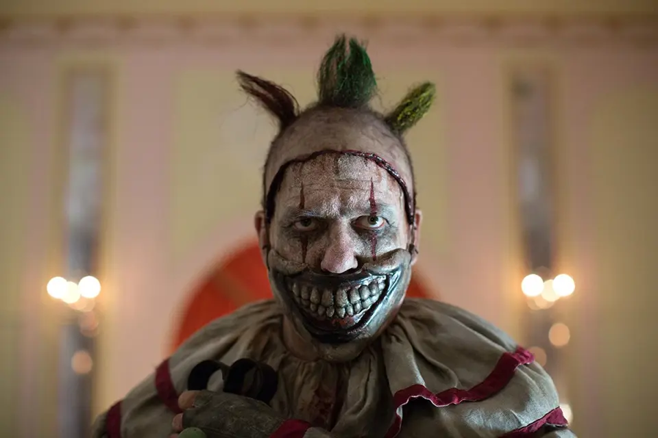 american-horror-story-twisty-the-clown-freak-show-john-carroll-lynch.jpg Twisty the Clown with his iconic disfigured smile prosthetic mask in American Horror Story: Freak Show (Season 4).